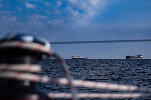 Sailing on the North Sea near Holland with freighter at anchor