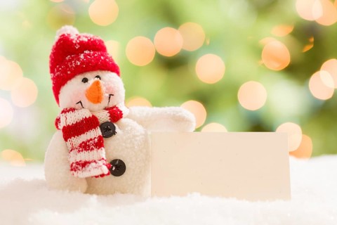 Cute snowman with scarf and hat next to blank white card over abstract background