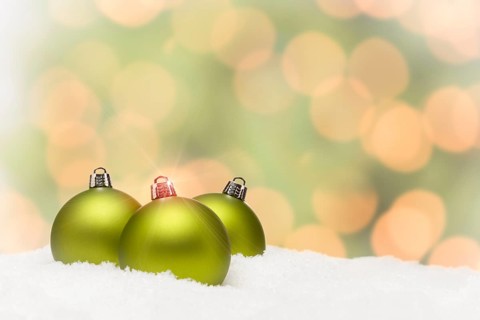 Beautiful matt green christmas ornaments on snow flakes over an abstract background with room for your own text