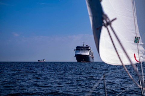 Sailing on the North Sea near Holland with freighter at anchor