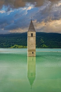 Church tower in the Reschensee with reflection