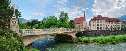 Art Nouveau postal bridge over the river Passer with hospital church of the Holy Spirit