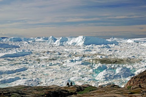 People in front of icebergs in fjord