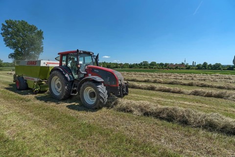 Farmer with tractor pressing hay