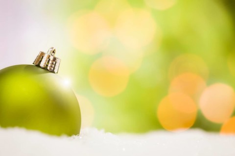 Beautiful matt green christmas ornaments on snow flakes over an abstract background with room for your own text
