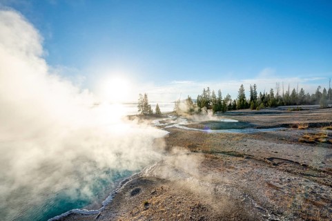 Steaming hot springs with turquoise water in the morning sun