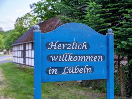 Wooden sign 'Welcome to Luebeln' at the entrance of the Rundlingsdorf Luebeln