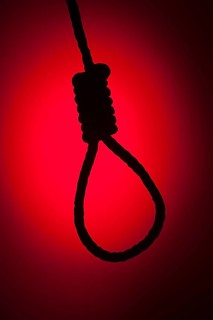 Silhouetted hangman's noose over red spot lit background