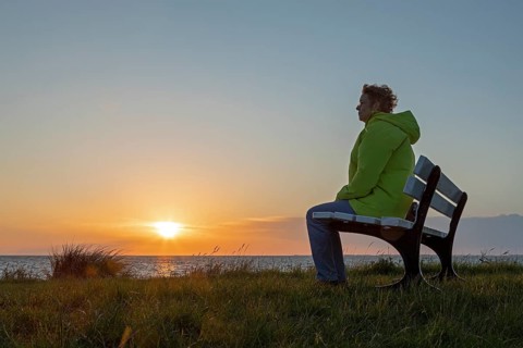 Woman enjoying the sunset on a bench