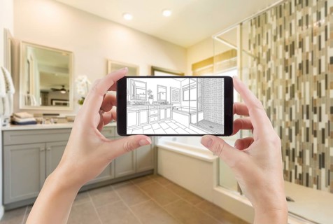 Hands holding smart phone with master bathroom drawing on screen and photo behind