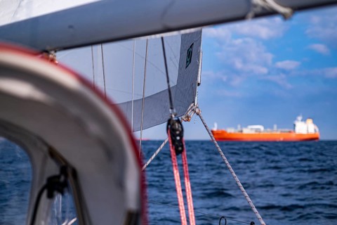 Sailing on the North Sea near Holland with freighter at anchor