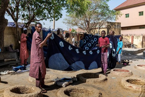 Men presenting indigo clothes at the dyeing pits
