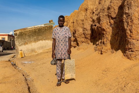 Young boy with the quran coming out of a medressa