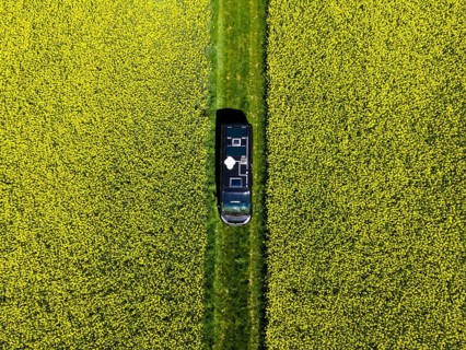 Drone shot of a camper van in a rape field