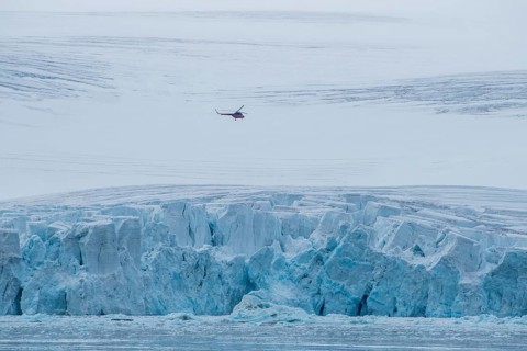 Helicopter flying over the giant icefield of Alexandra Land