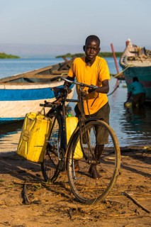 Boy filling water in canisters at Lake Albert