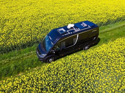Drone shot of a camper van in a rape field
