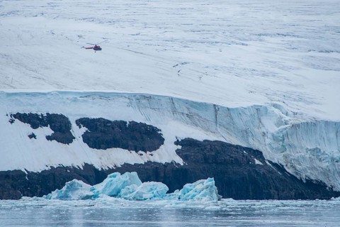Helicopter flying over the giant icefield of Alexandra Land