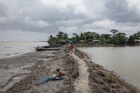 Woman walking on a muddy embankment