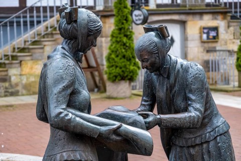 Sculpture of two linen weavers at the fountain in front of the town hall in Luechow