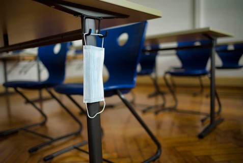 Mouth mask hangs on student's desk
