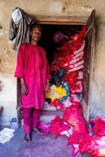Shopkeeper before his shop full of colourful leather