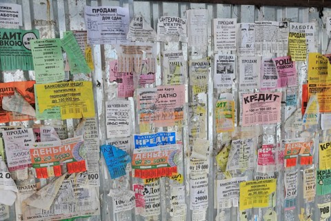 Taped to construction fence offers for loans in Panteleimonovskaya Street