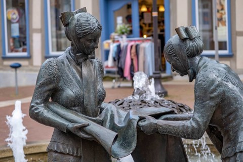 Sculpture of two linen weavers at the fountain in front of the town hall in Luechow
