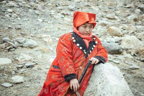 Girl in Kyrgyz traditional costume during the rest of a caravan