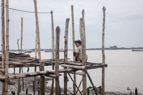A boy sits on a jetty