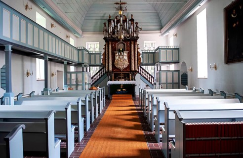 Interior with wooden barrel vault and pulpit altar of St. Nicholas Church