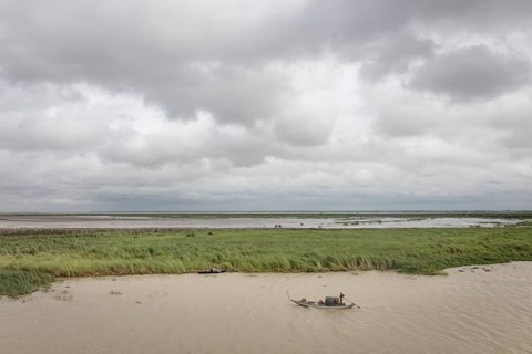 Punt with fisherman on the Poschur River in the Sundarbans