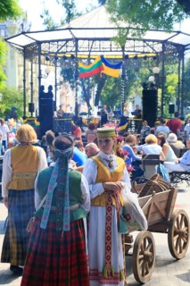 Folk group in traditional costumes in front of the music pavilion in the city garden