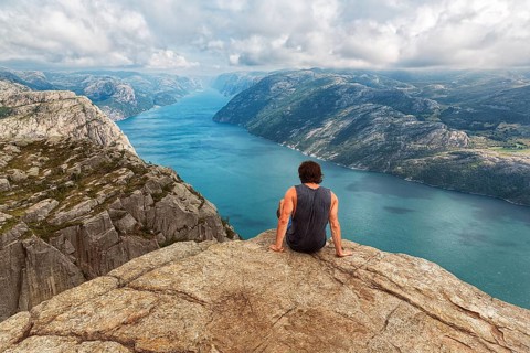 Hiker sitting on rock pulpit Preikestolen