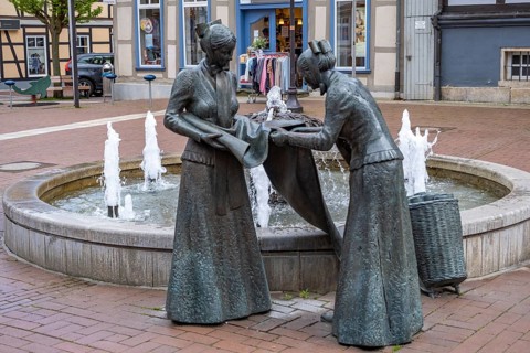 Sculpture of two linen weavers at the fountain in front of the town hall in Luechow