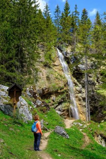 Hiker in front of the Arzmoos waterfall