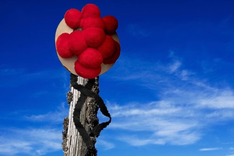 Original Black Forest Bollen hat on wooden post in front of blue sky