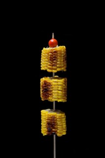 Grilled corn on the corn cob on a skewer