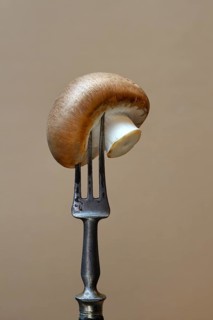 Brown cultivated mushroom on fork