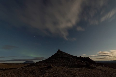 Faint northern lights (Aurora Borealis) and star trails