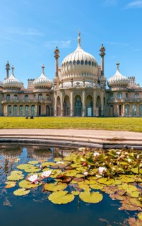 Royal Pavilion palace reflected in a pond with water lilies