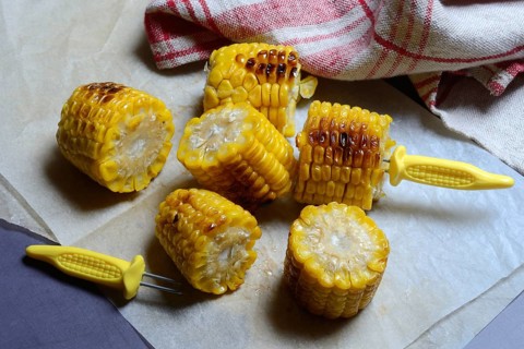 Roasted corn on the corn cob with corn on the cob holder