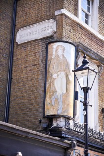 Duke of Sussex sign on yellow brick wall and old street lamp