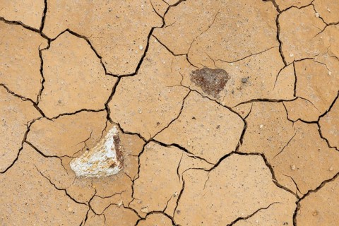 Cracks in the clay soil and coloured rhyolite rock