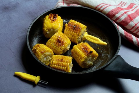 Fried corn on the corn cob in pan