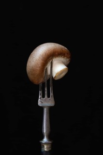 Brown cultivated mushroom on fork