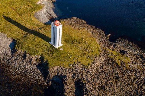 Lighthouse and coastal landscape with basalt formations