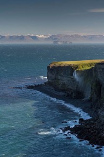 Waterfall falls over cliff and is blown away by wind