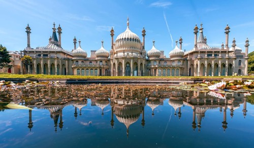 Royal Pavilion palace reflected in a pond with water lilies