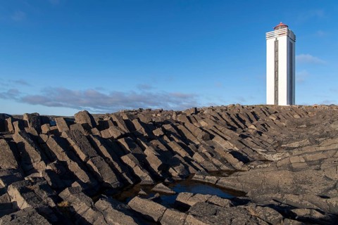 Lighthouse and coastal landscape with basalt formations